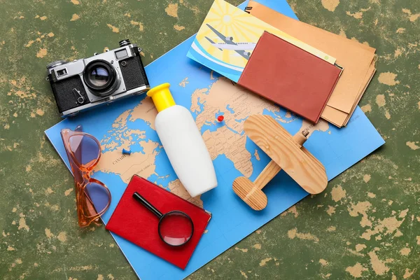 写真カメラ パスポート 木製の飛行機 日焼け止めボトル サングラス 緑の背景の地図 — ストック写真