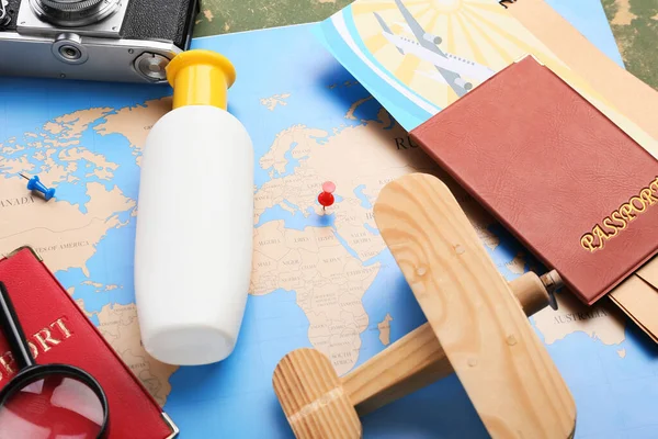 Holzflugzeug Reisepass Und Sonnenschutzflasche Auf Der Karte Nahaufnahme — Stockfoto