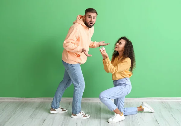 Mujer Joven Proponiendo Novio Sorprendido Fondo Color — Foto de Stock