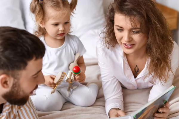 Ευτυχισμένη Νεαρή Οικογένεια Ανάγνωση Βιβλίο Στο Υπνοδωμάτιο Στο Σπίτι — Φωτογραφία Αρχείου