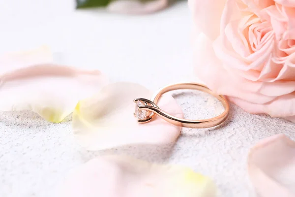 Hermoso Anillo Compromiso Dorado Con Pétalos Rosa Sobre Fondo Claro —  Fotos de Stock