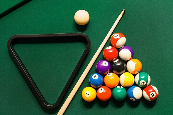 Farklı bilardo topları ve yeşil masada raflar.