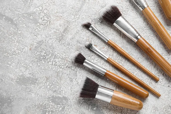 Gri arkaplanda güzel makyaj fırçaları.