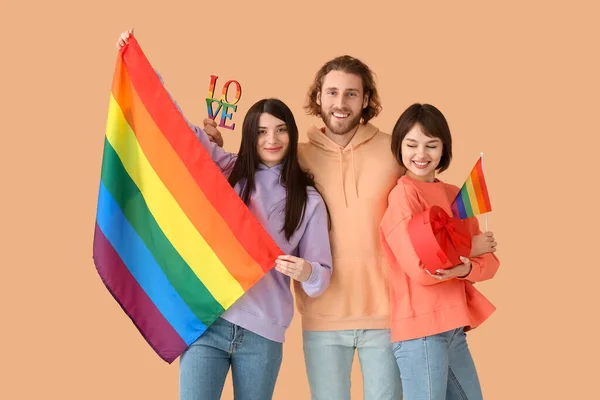 虹の旗 贈り物 色の背景に言葉の愛を持つ男と2人の美しい女性 一夫多妻制とLgbtの概念 — ストック写真