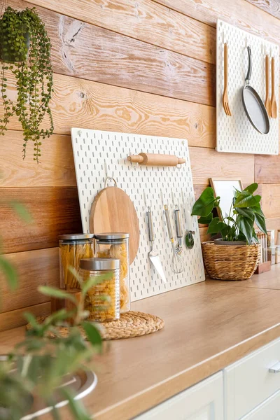 木墙附近的厨房柜台上有厨房用具的小木板 — 图库照片