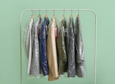 Yeşil arka planda plastik poşetlerde temiz ceketli raflar