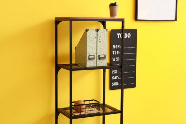 Renk duvarında listelenecek dizinleri ve tahtası olan raf ünitesi, kapat