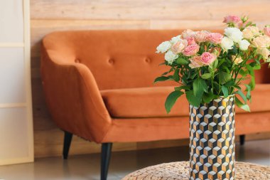 Oturma odasında üzerinde güzel güller olan bir vazo, yakın plan.