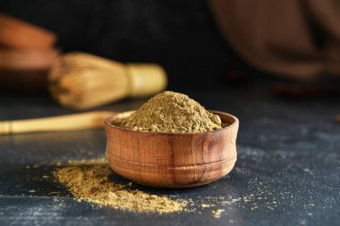 Siyah arka planda hojicha pudrası olan kase