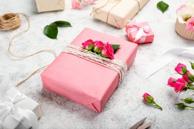 Güllerle dolu güzel hediye kutuları ve grunge arka planında ip