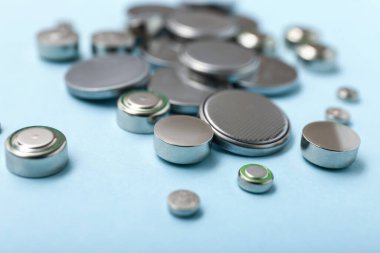 Mavi arkaplanda lityum düğmeli hücre pilleri, yakın plan