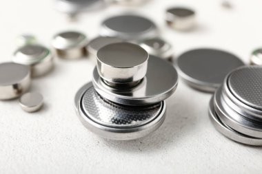 Metal lityum düğmeli hücre pilleri beyaz arkaplanda, yakın plan