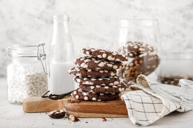 Masanın üzerinde beyaz çikolata parçacıkları ve lezzetli kurabiyelerden oluşan ahşap bir tahta.