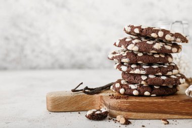 Masanın üzerinde beyaz çikolata parçacıkları ve lezzetli kurabiyelerden oluşan ahşap bir tahta.