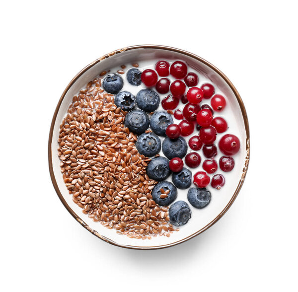 Bowl of sweet yogurt with flax seeds and berries on white background