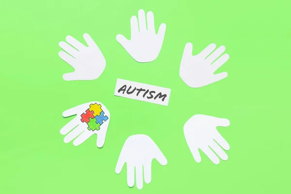 带有彩色拼图和颜色背景的单词Autism的人类手掌纸 — 图库照片