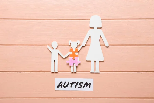 彩色木制背景下带有单词Autism的家族和拼图 — 图库照片