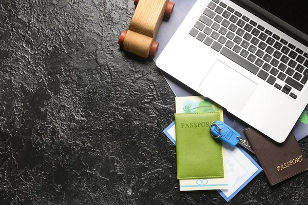 Laptop Mit Holzauto Reisepässen Und Gutschein Auf Dunklem Hintergrund — Stockfoto