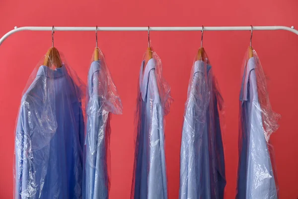 Rack Tiszta Kék Ingek Műanyag Zacskókban Rózsaszín Háttér — Stock Fotó