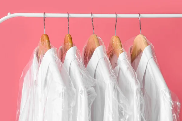 ピンクの背景にビニール袋にきれいな白いシャツとラック クローズアップ — ストック写真