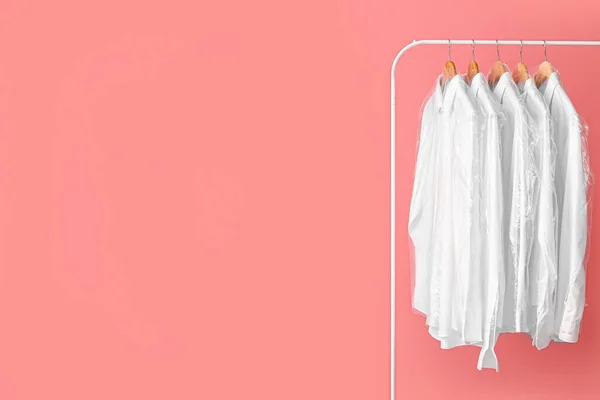 Cremalheira Com Camisas Brancas Limpas Sacos Plástico Sobre Fundo Rosa — Fotografia de Stock