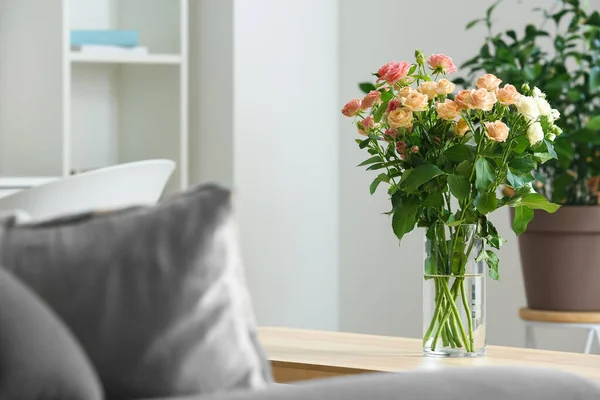 部屋のテーブルの上に美しい新鮮なバラの花束と花瓶 — ストック写真