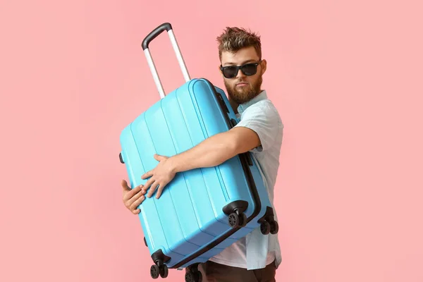Schöner Mann Mit Sonnenbrille Und Blauem Koffer Auf Rosa Hintergrund — Stockfoto
