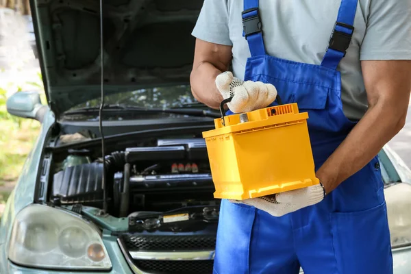 Mannelijke Monteur Met Moderne Auto Batterij Buiten — Stockfoto