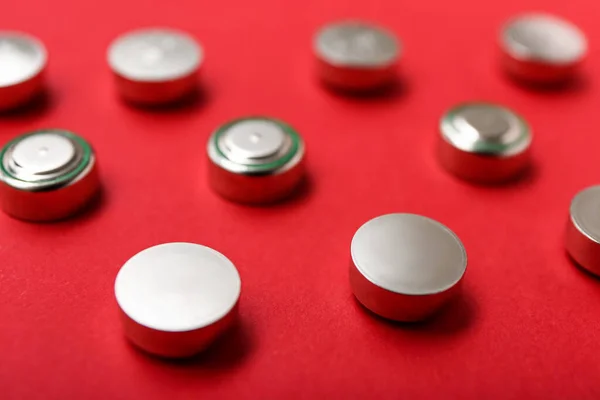 Kırmızı Arkaplanda Metal Lityum Düğmeli Hücre Pilleri Yakın Plan — Stok fotoğraf