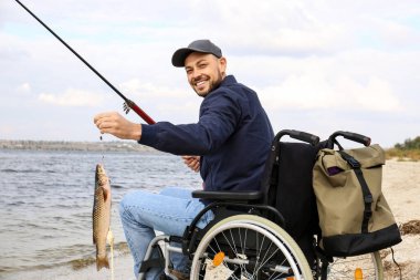 Tekerlekli sandalyede balık tutan adam