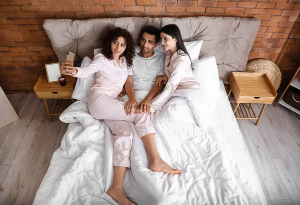 2人の美しい女性と男がベッドで自撮り 一夫多妻制 — ストック写真