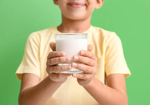 緑の背景にミルクのガラスの小さな男の子 クローズアップ — ストック写真