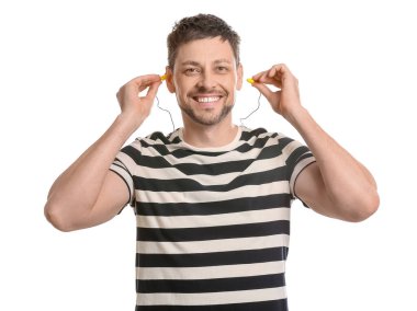 Beyaz arka planda kulak tıkacı olan çizgili tişörtlü yakışıklı bir adam.