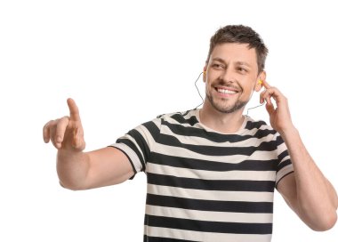 Kulak tıkacı olan yakışıklı adam beyaz arka plandaki bir şeyi işaret ediyor.