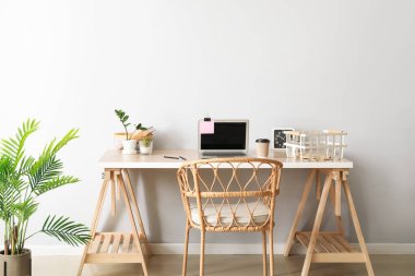 Laptop ve hasır koltuklu modern işyeri
