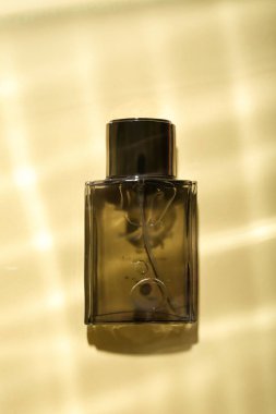 Renkli arka planda sudaki erkekler için bir şişe parfüm.