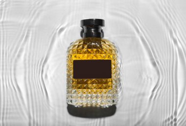 Hafif arka planda suda yaşayan erkekler için bir şişe parfüm.