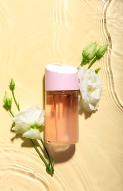 Renkli arka planda bir şişe parfüm ve çiçek.