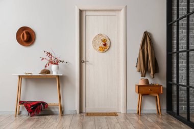 Modern koridorun içinde, ışık duvarının yanında şık masalar var.