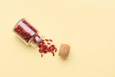 Sarı arka planda kurutulmuş böğürtlen kavanozu.