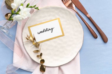 Güzel masa düzenleme ve mavi arka planda düğün davetiyesi