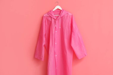 Pembe duvarda asılı şık bir yağmurluk
