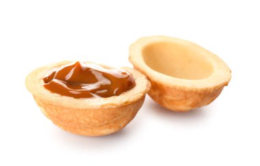 Beyaz arka planda kaynamış yoğunlaştırılmış sütle lezzetli ceviz şekilli kurabiye.