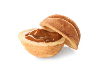 Beyaz arka planda kaynamış yoğunlaştırılmış sütle lezzetli ceviz şekilli kurabiye.