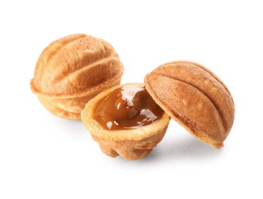 Lezzetli ceviz şekilli kurabiyeler ve beyaz arka planda kaynamış konsantre süt.