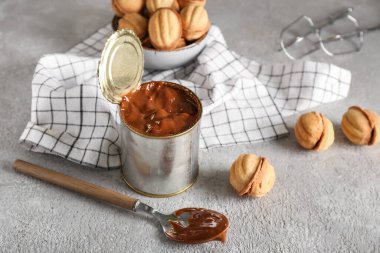 Kaynamış konsantre süt ve fındık şekilli kurabiyelerle dolu teneke kutu.