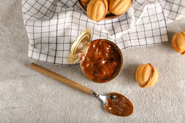 Kaynamış konsantre süt ve fındık şekilli kurabiyelerle dolu teneke kutu.