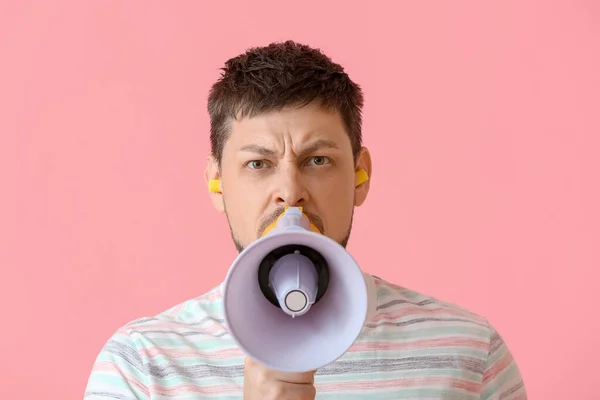 Angry Young Man Ear Plugs Shouting Megaphone Pink Background — Stock Photo, Image