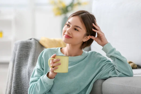 漂亮的年轻女子在家里喝着美味的茶 — 图库照片