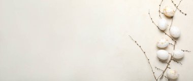 Açık arkaplan üzerinde güzel Paskalya yumurtaları ve ağaç dalları ve metin için boşluk